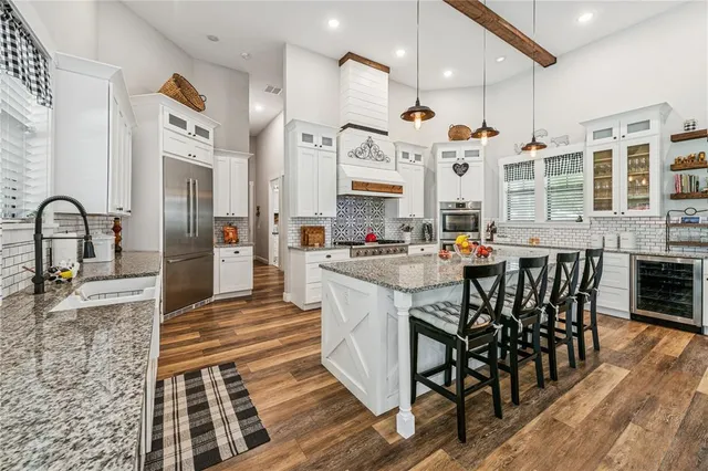 a open kitchen with stainless steel appliances granite countertop a stove and a sink