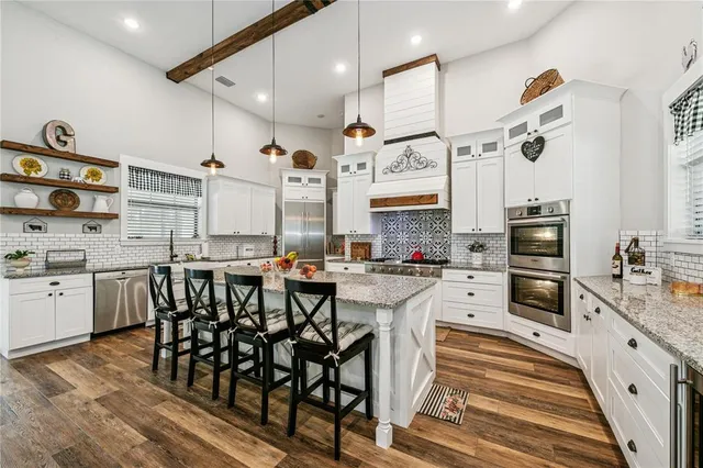 a kitchen with stainless steel appliances kitchen island granite countertop a sink and cabinets