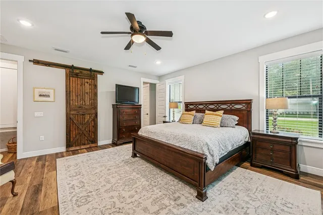 a bedroom with a large bed a flat tv screen and dresser