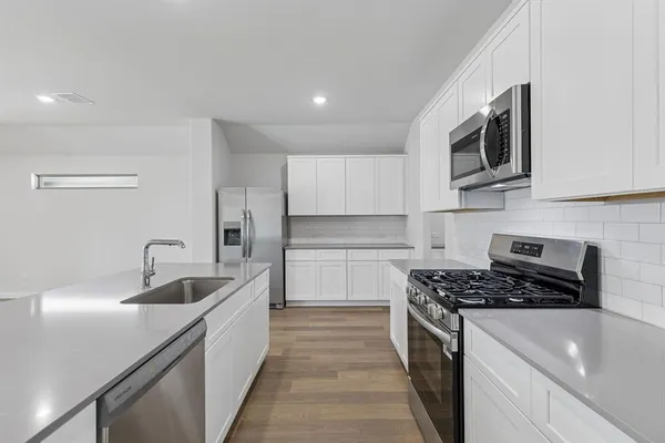 a kitchen with stainless steel appliances granite countertop a sink and a stove
