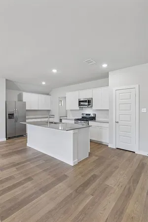 a large kitchen with kitchen island a sink stainless steel appliances and cabinets