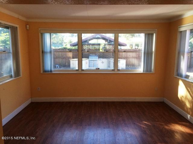 6520 Diane Road Jacksonville, FL 32277 - Photo 5 of 16 an empty room with wooden floor and windows