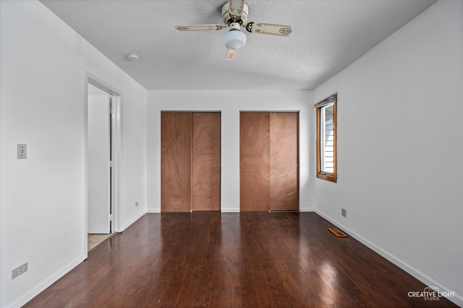 937 Sandpiper Court Bartlett, IL 60103 - Photo 13 of 17 an empty room with wooden floor chandelier fan and windows