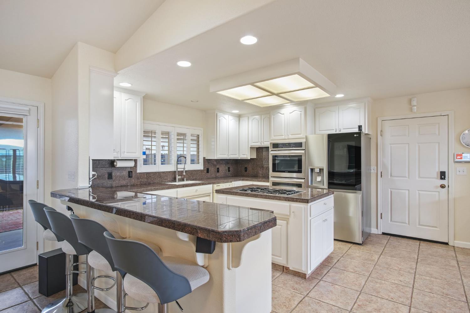 845 Pointe Lourose Avenue Gustine, CA 95322 - Photo 11 of 34 a kitchen with stainless steel appliances granite countertop a sink and a refrigerator