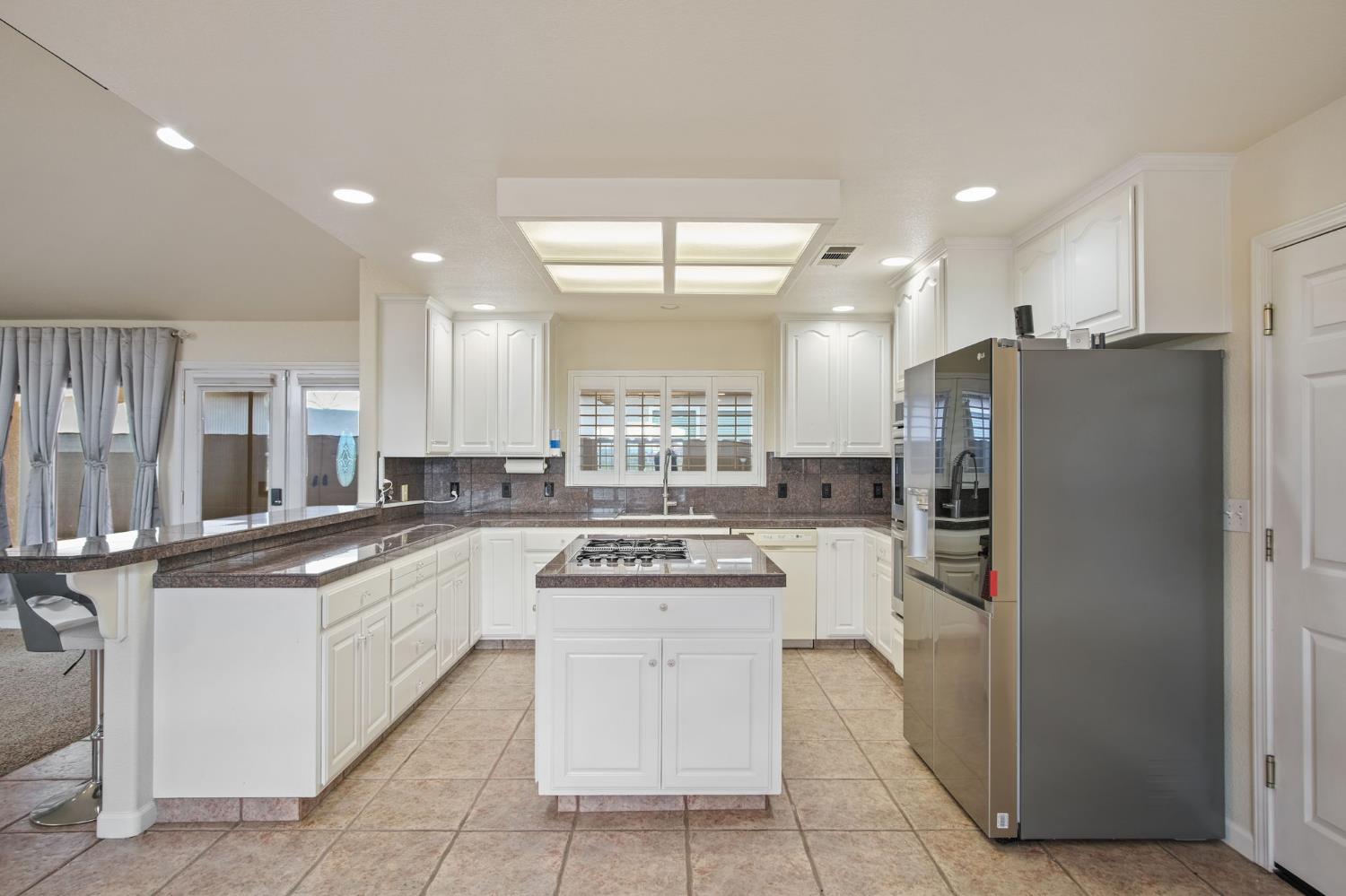 845 Pointe Lourose Avenue Gustine, CA 95322 - Photo 12 of 34 a kitchen with stainless steel appliances granite countertop a refrigerator and a stove