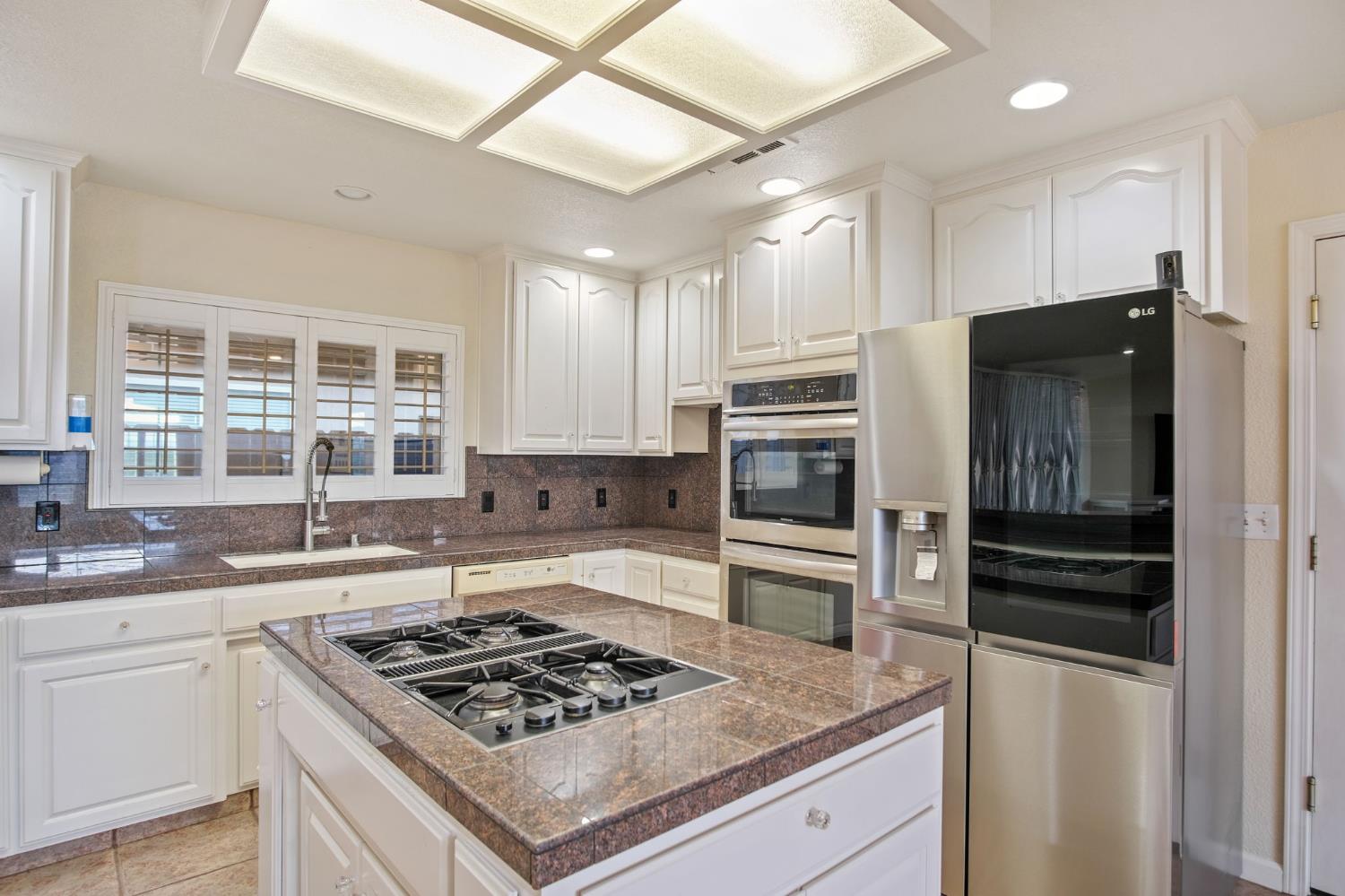 845 Pointe Lourose Avenue Gustine, CA 95322 - Photo 13 of 34 a kitchen with a stove a sink and a refrigerator