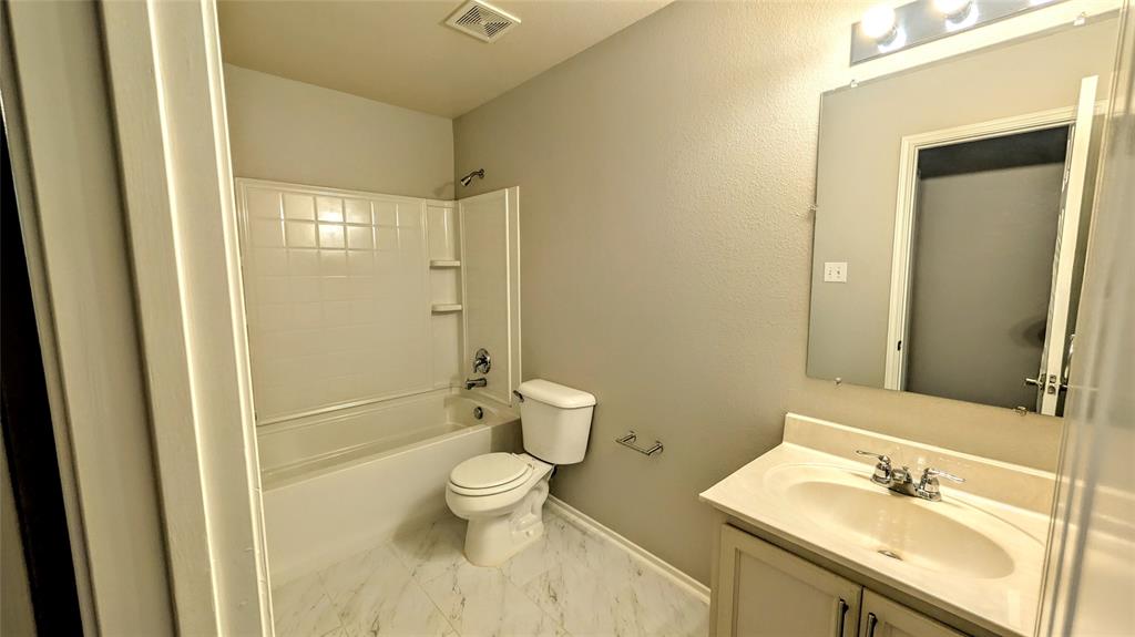 1308 Lamar Lane Allen, TX 75002 - Photo 15 of 40 Bathroom featuring vanity, shower / bathtub combination, and marble look tile flooring