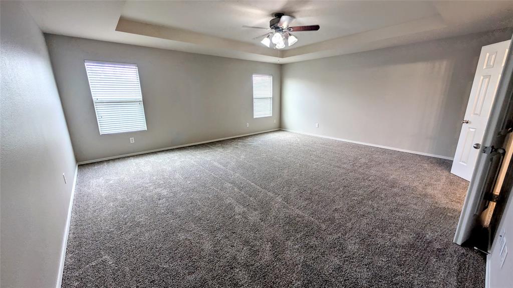 1308 Lamar Lane Allen, TX 75002 - Photo 19 of 40 Carpeted empty room featuring a raised ceiling and ceiling fan