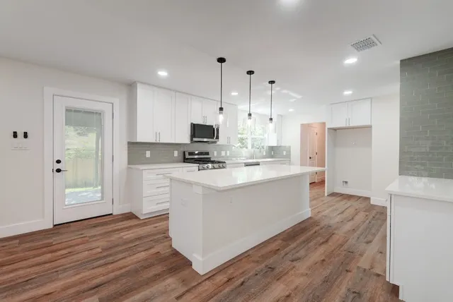 a kitchen with white cabinets and stainless steel appliances