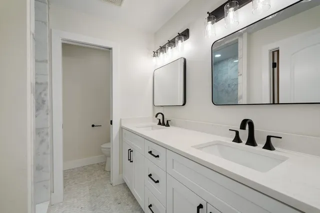 a bathroom with a double vanity sink and mirror
