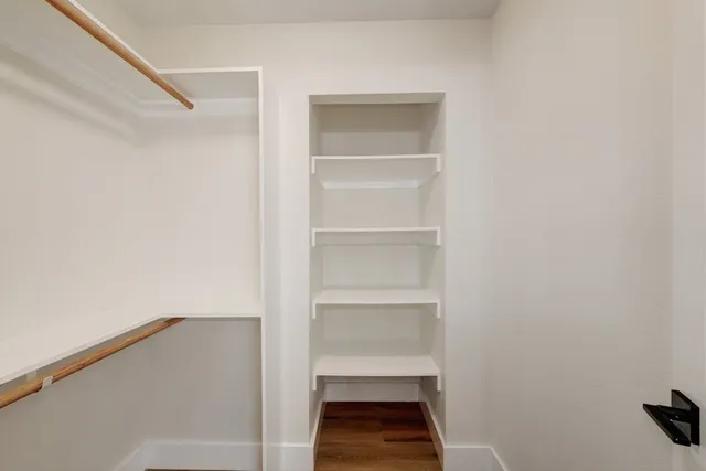 a view of walk in closet with empty racks
