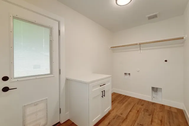 a view of a storage and utility room with wooden floor