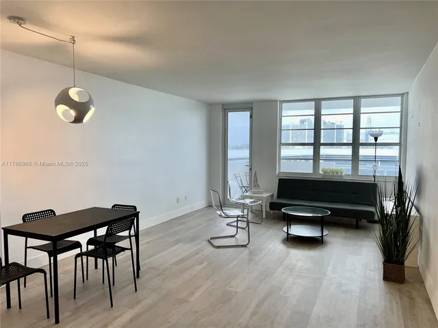 a living room with furniture a rug and a floor to ceiling window