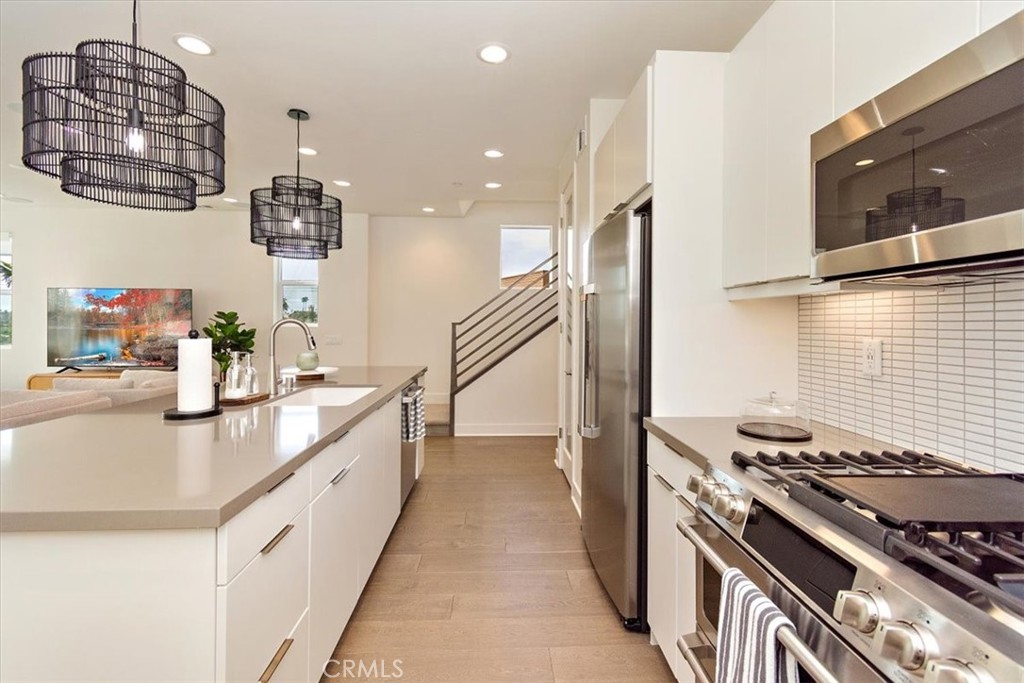 1030 Harbor Boulevard Oxnard, CA 93035 - Photo 13 of 40 a kitchen with kitchen island granite countertop a stove and a sink