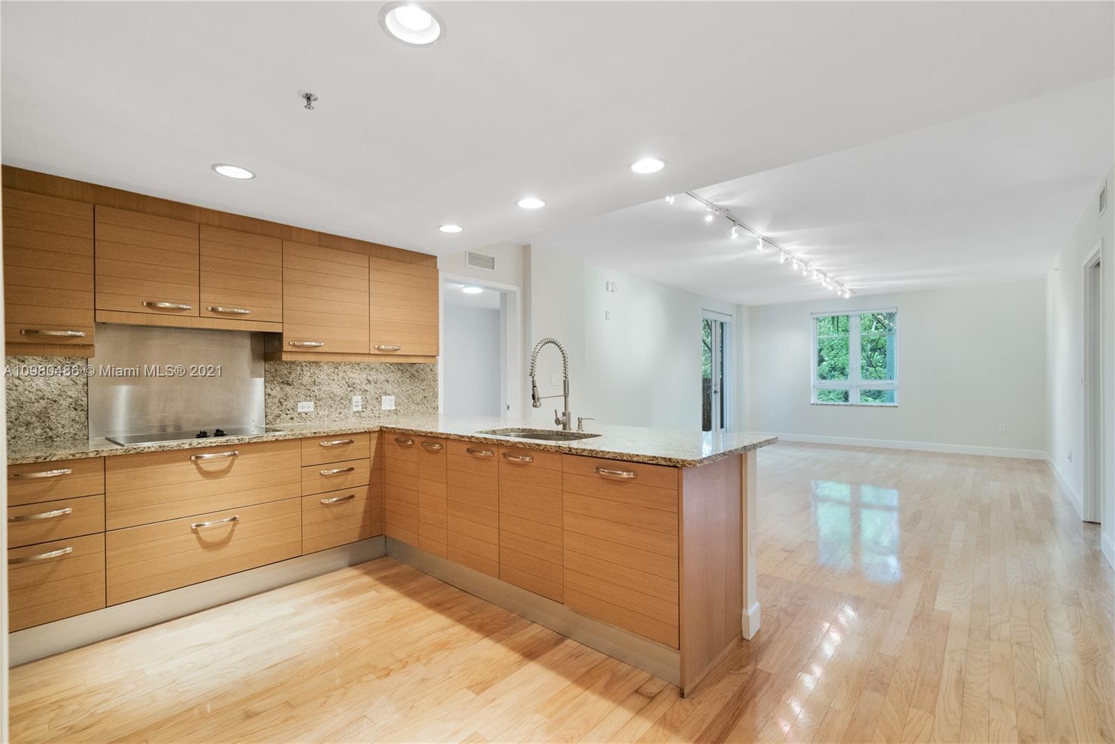3540 Main Highway, Unit 309 Miami, FL 33133 - Photo 1 of 34 a large kitchen with stainless steel appliances kitchen island granite countertop a sink and cabinets