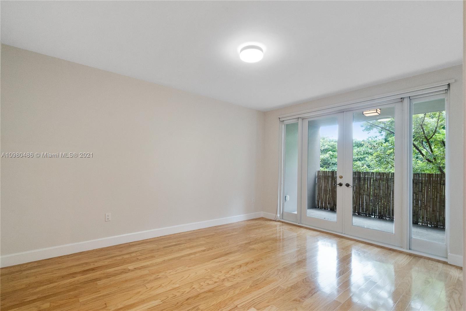 3540 Main Highway, Unit 309 Miami, FL 33133 - Photo 19 of 34 a view of an empty room with wooden floor and a window