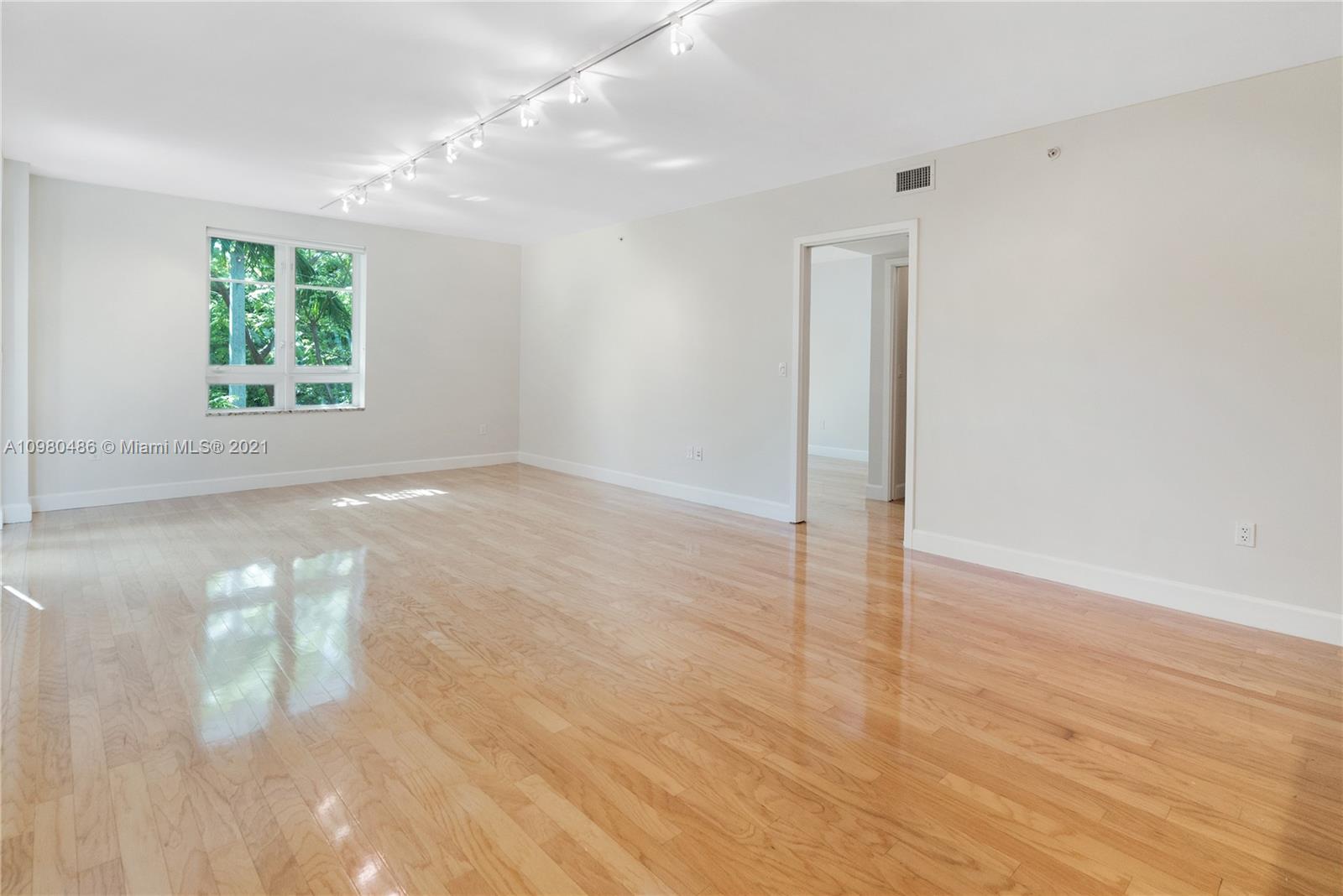 3540 Main Highway, Unit 309 Miami, FL 33133 - Photo 4 of 34 an empty room with wooden floor and windows