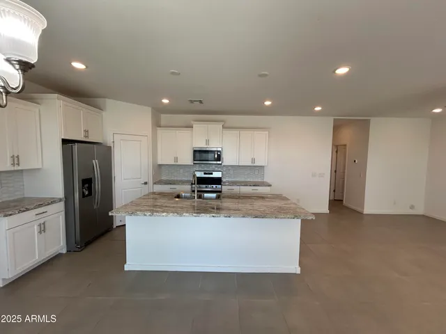 a large kitchen with stainless steel appliances granite countertop a granite counter tops and white cabinets