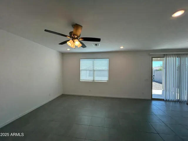 an empty room with a window and a ceiling fan