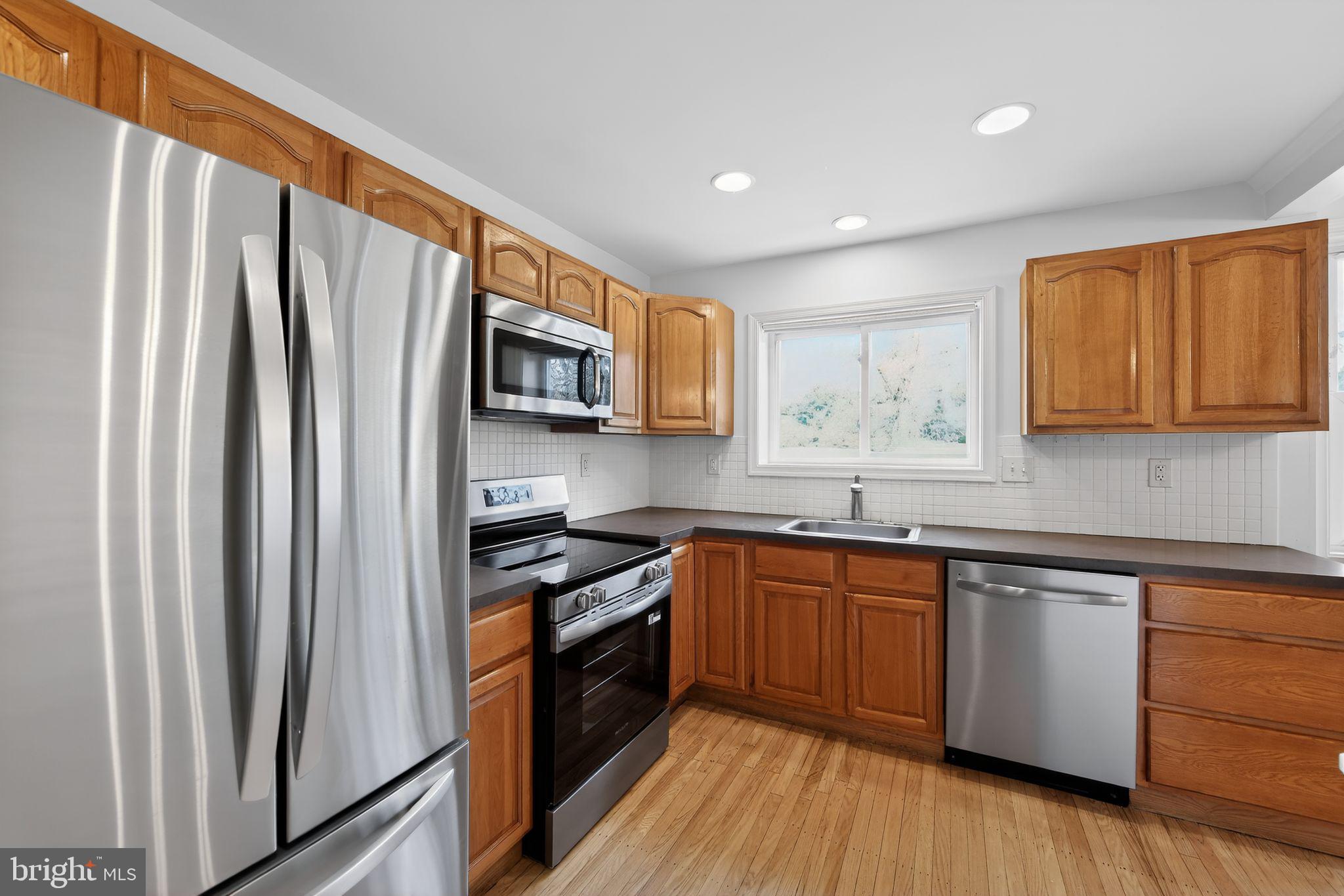 1567 Sugartown Road Paoli, PA 19301 - Photo 13 of 32 a kitchen with stainless steel appliances granite countertop a refrigerator a stove top oven a sink and dishwasher