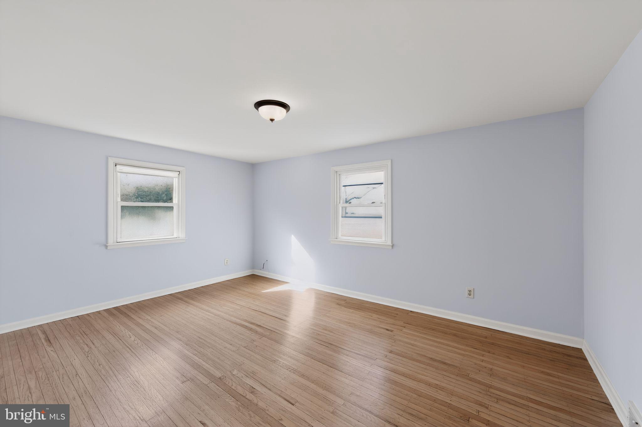1567 Sugartown Road Paoli, PA 19301 - Photo 15 of 32 a view of an empty room with wooden floor and a window