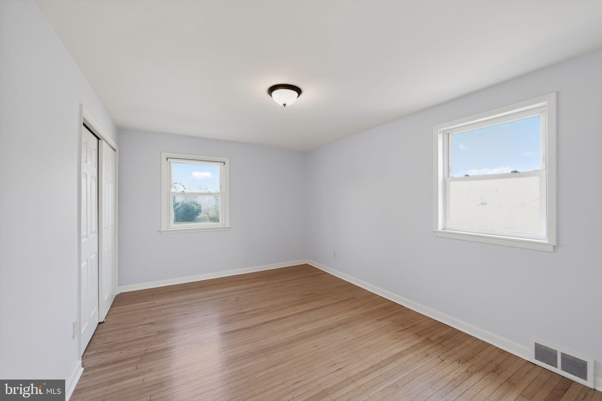 1567 Sugartown Road Paoli, PA 19301 - Photo 18 of 32 an empty room with wooden floor and windows