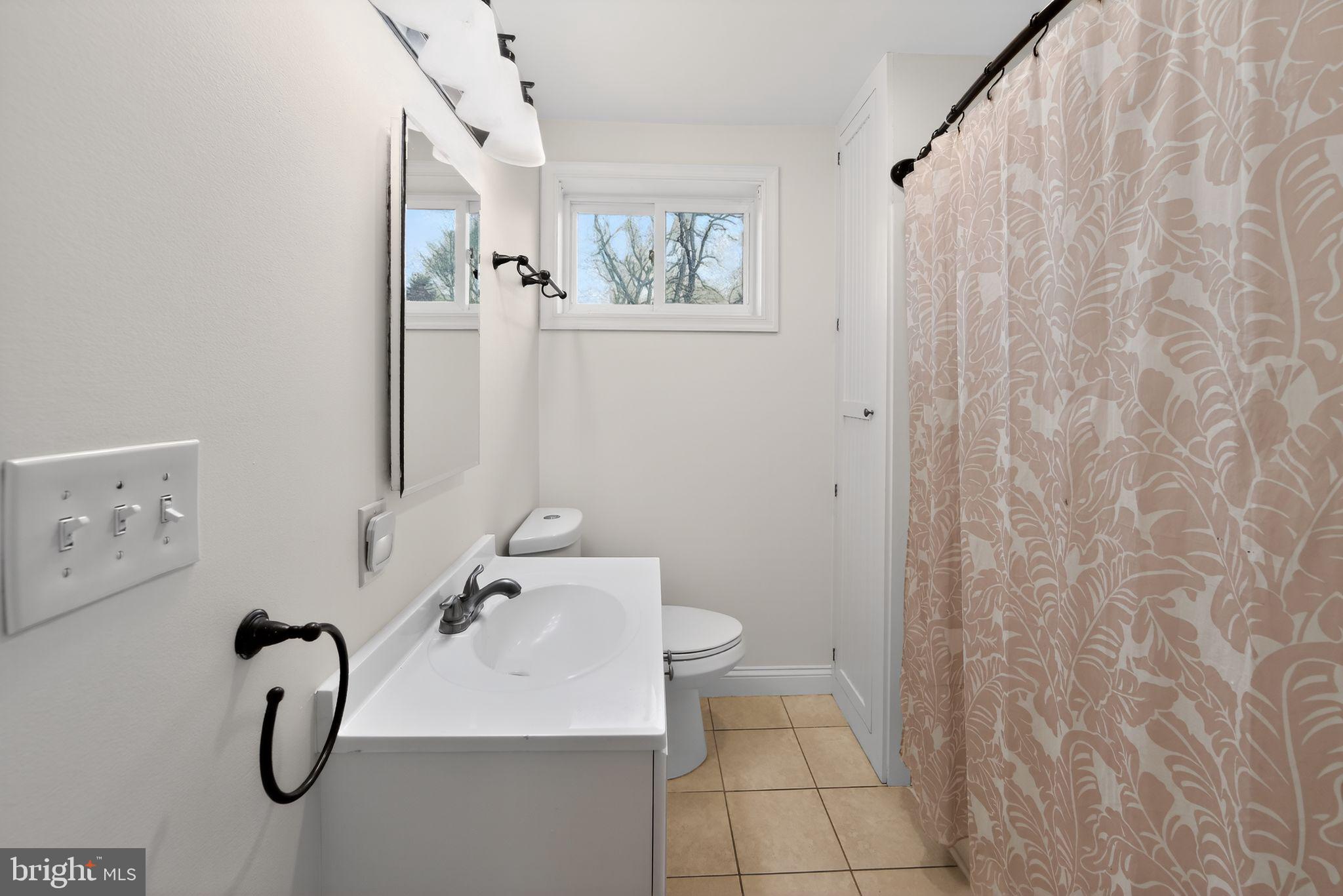 1567 Sugartown Road Paoli, PA 19301 - Photo 22 of 32 a bathroom with a sink vanity mirror and toilet