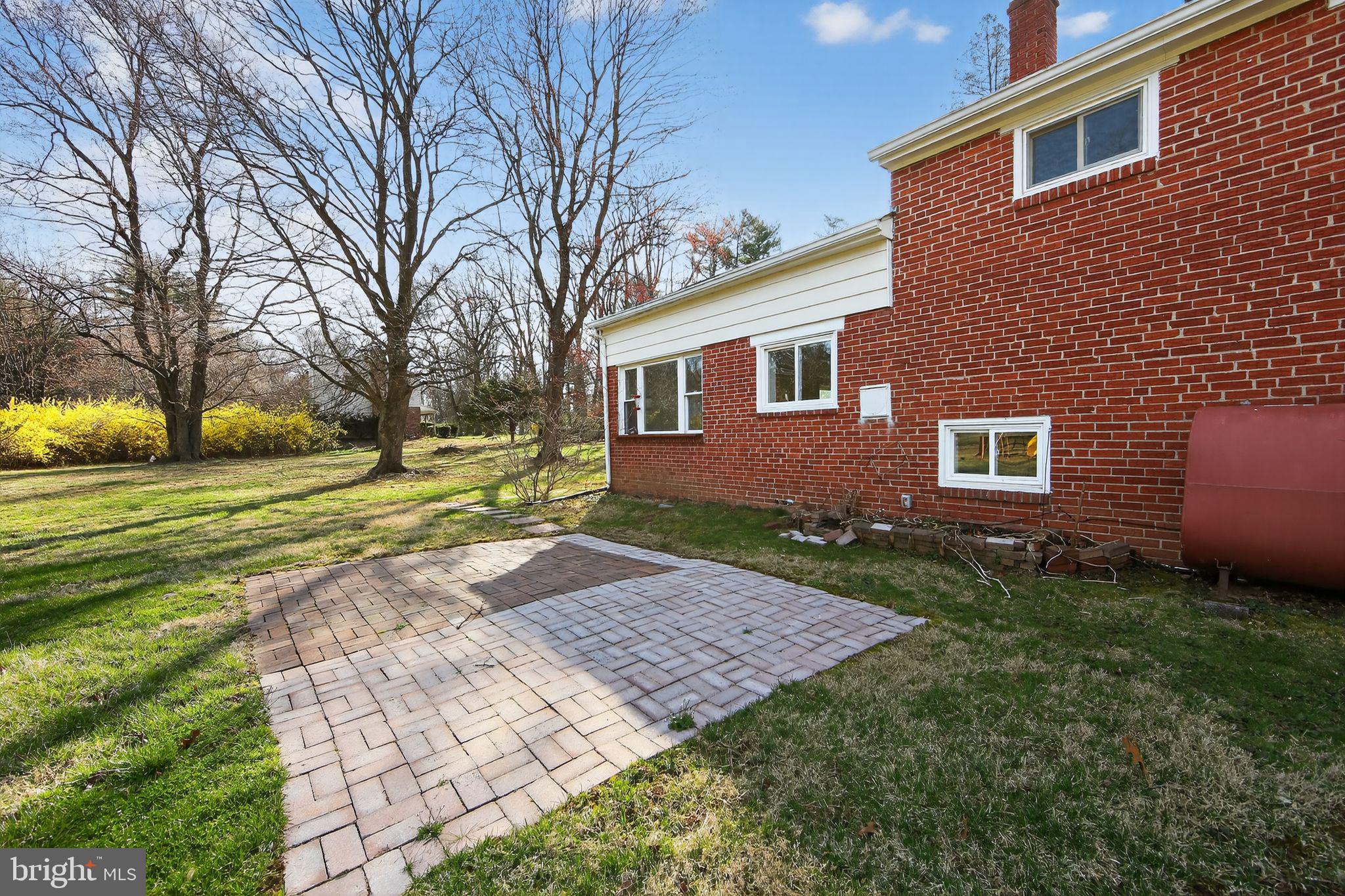 1567 Sugartown Road Paoli, PA 19301 - Photo 28 of 32 a view of a yard in front of a brick house with large windows
