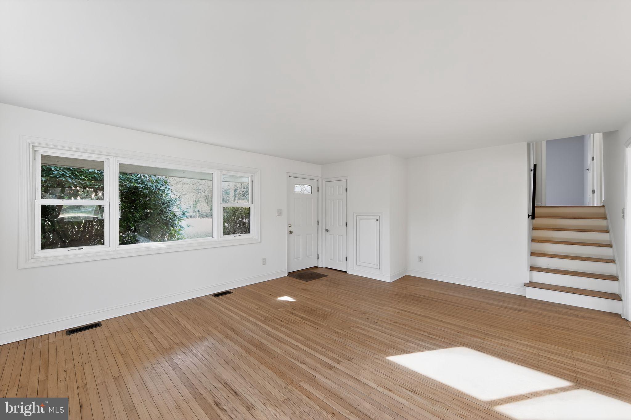 1567 Sugartown Road Paoli, PA 19301 - Photo 4 of 32 a view of an empty room with wooden floor and a window