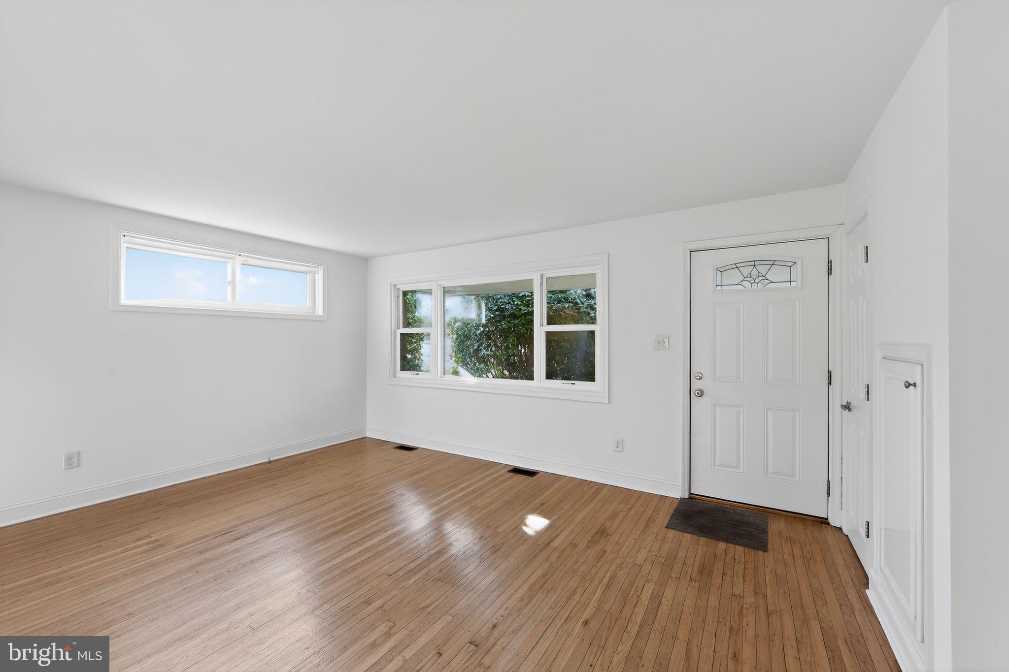 1567 Sugartown Road Paoli, PA 19301 - Photo 5 of 32 a view of an empty room with wooden floor and a window