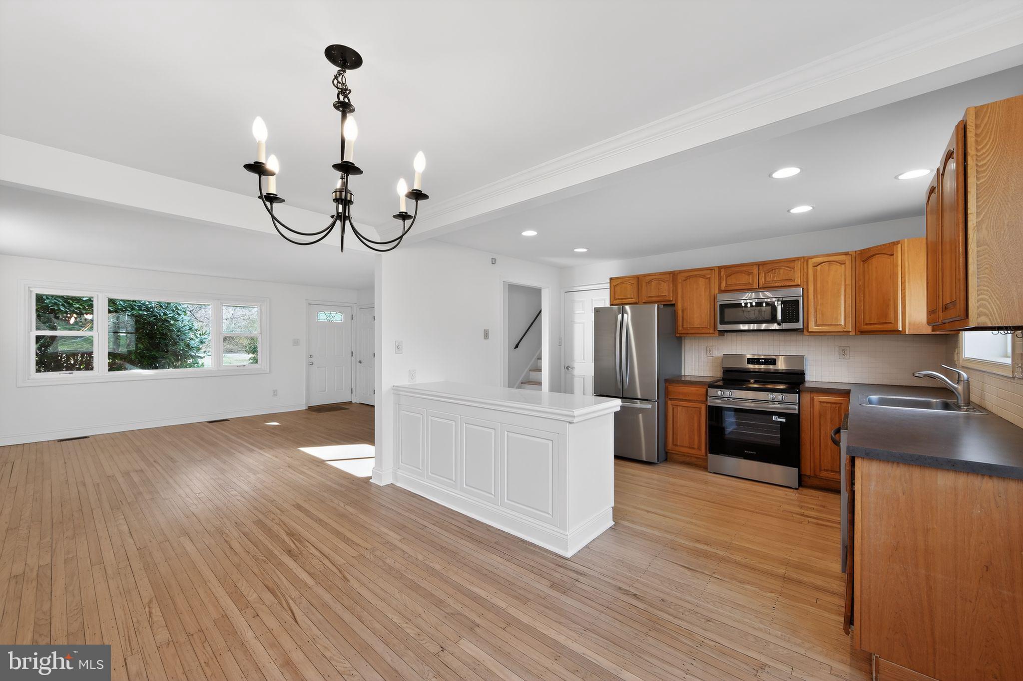 1567 Sugartown Road Paoli, PA 19301 - Photo 8 of 32 a kitchen with stainless steel appliances granite countertop a refrigerator a stove oven a sink dishwasher and white cabinets with wooden floor