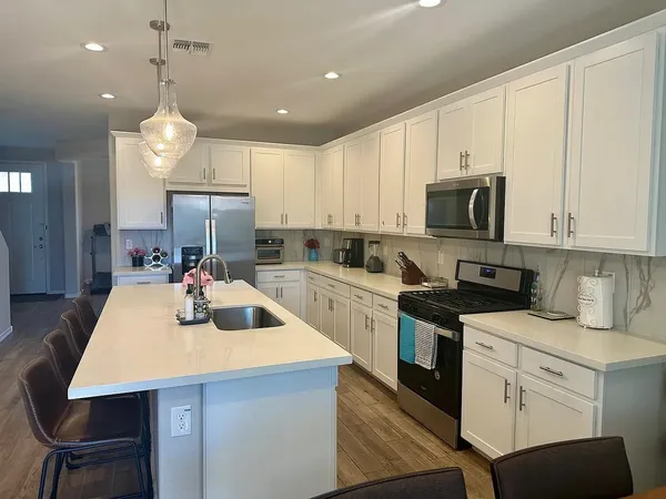 a kitchen with a table chairs sink and cabinets