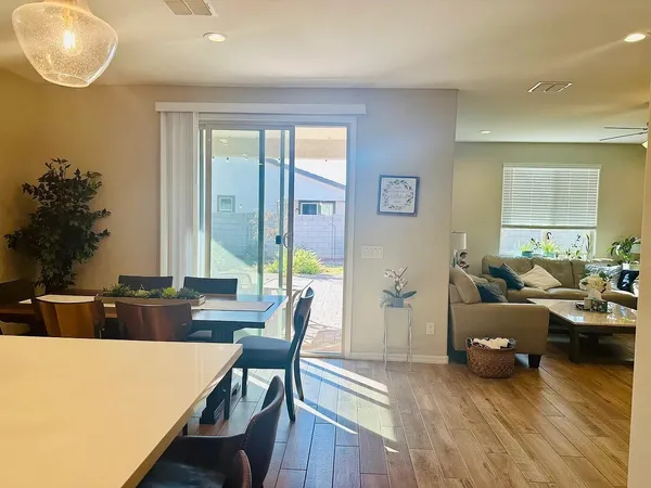 a living room with furniture kitchen view and a wooden floor