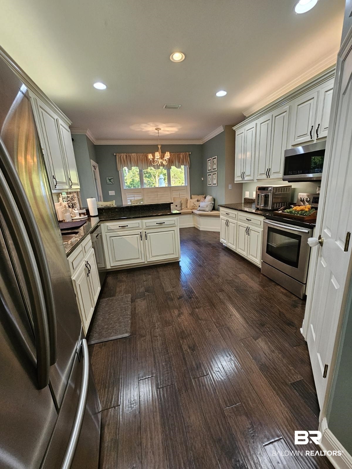 41416 Davis Duck Road Bay Minette, AL 36507 - Photo 29 of 72 Kitchen with appliances with stainless steel finishes, decorative light fixtures, ornamental molding, dark hardwood / wood-style floors, and kitchen peninsula