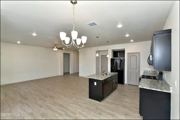 a kitchen with stainless steel appliances granite countertop a sink a refrigerator and a stove