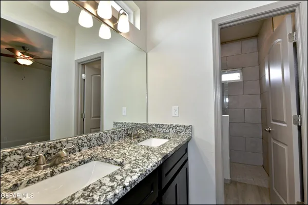a bathroom with a granite countertop sink and a mirror