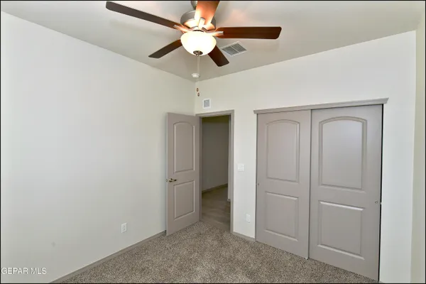 an empty room with a window and a fan