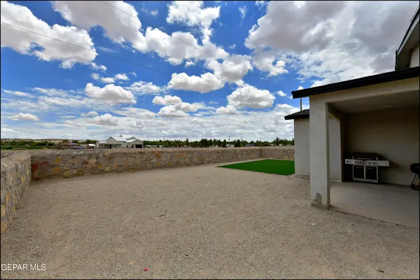 a backyard of a house with table and chairs
