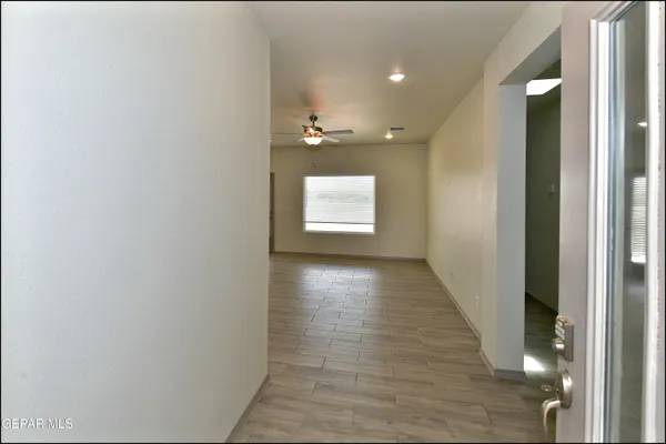 a view of a hallway with wooden floor and a large window