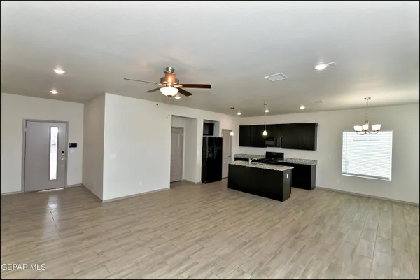 a large kitchen with a refrigerator and a stove top oven