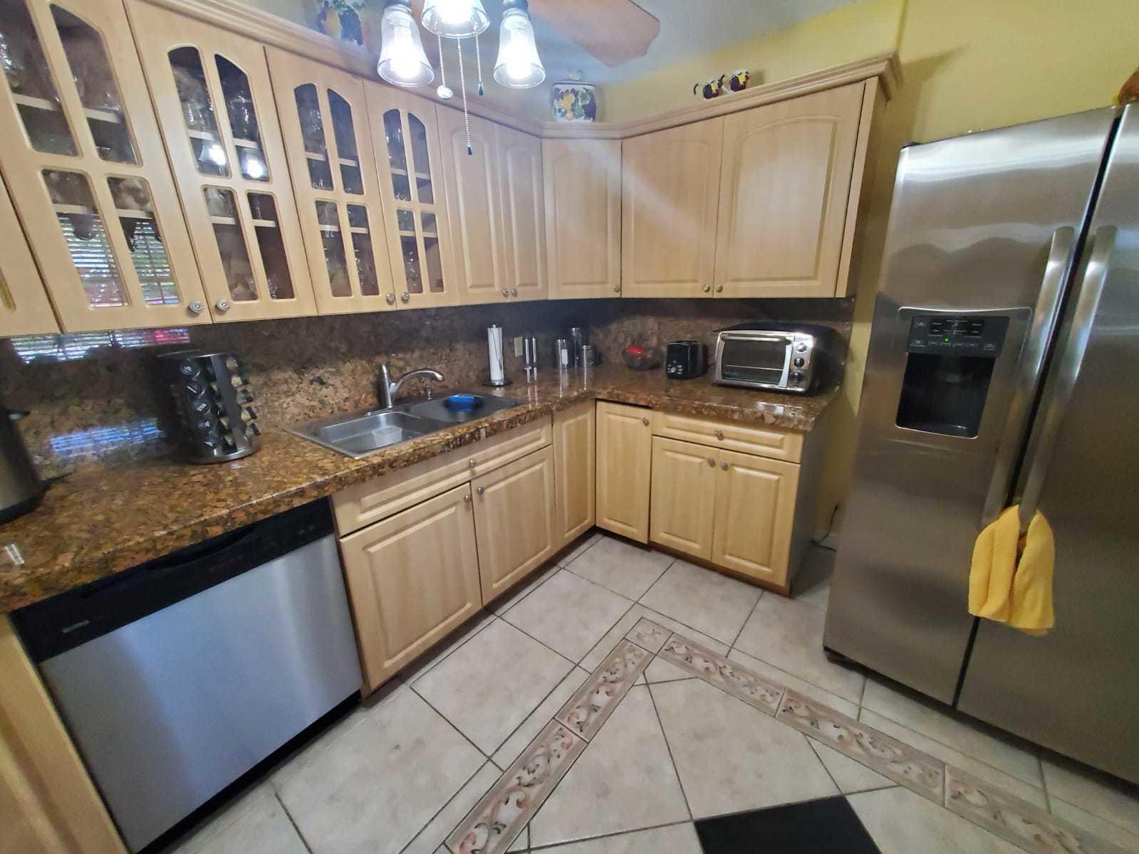 437 Kirk Road Palm Springs, FL 33461 - Photo 11 of 53 a kitchen with stainless steel appliances granite countertop a sink stove and cabinets