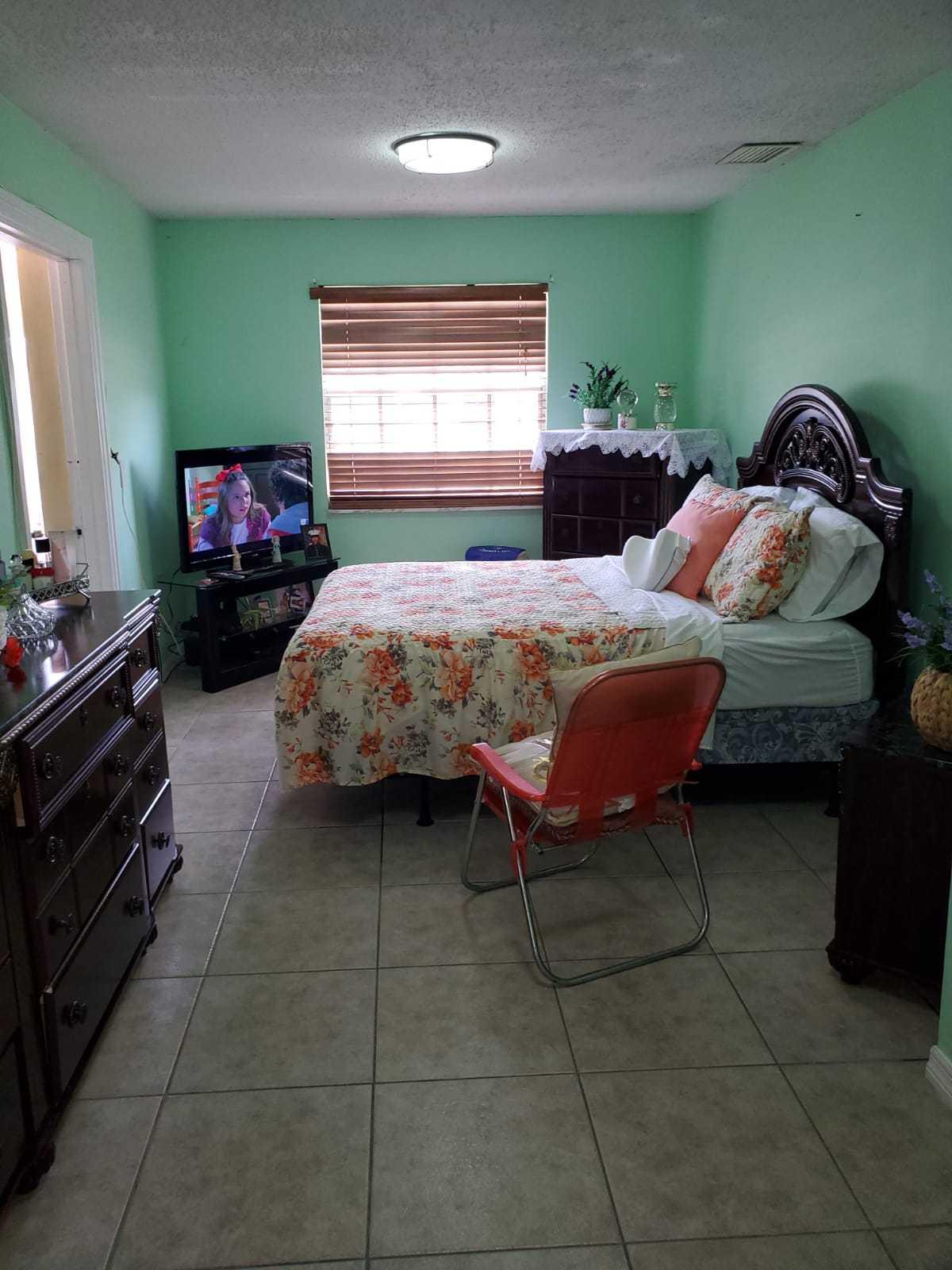 437 Kirk Road Palm Springs, FL 33461 - Photo 49 of 53 a bedroom with a bed and a flat tv screen on dresser
