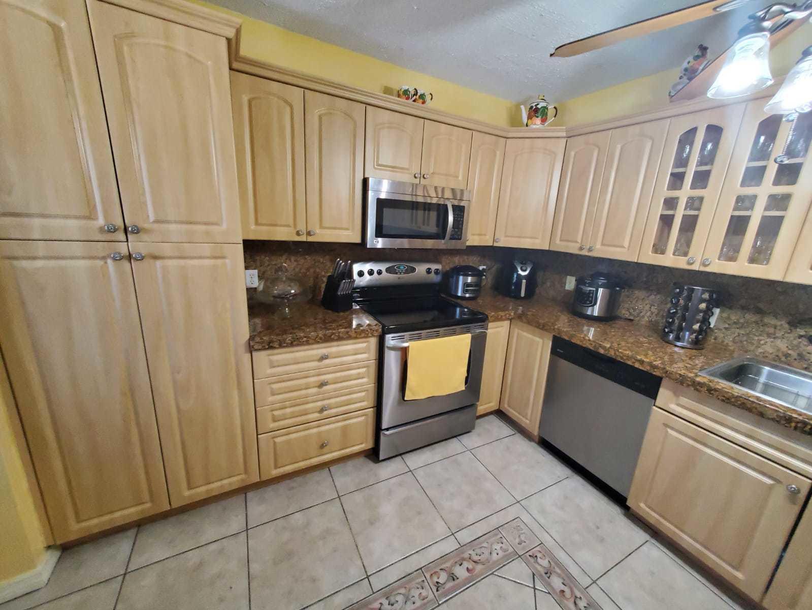 437 Kirk Road Palm Springs, FL 33461 - Photo 9 of 53 a kitchen with granite countertop a stove sink and cabinets