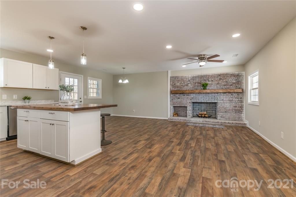 310 Webb Church Road Ellenboro, NC 28040 - Photo 16 of 35 a large kitchen with granite countertop a stove top oven a sink and white cabinets with wooden floor