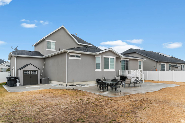5686 Duke Lane Tooele, UT 84074 - Photo 7 of 38 Back of property with a patio, stucco siding, and a shed