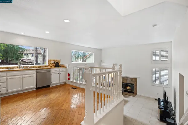 a kitchen with white cabinets and wooden floor