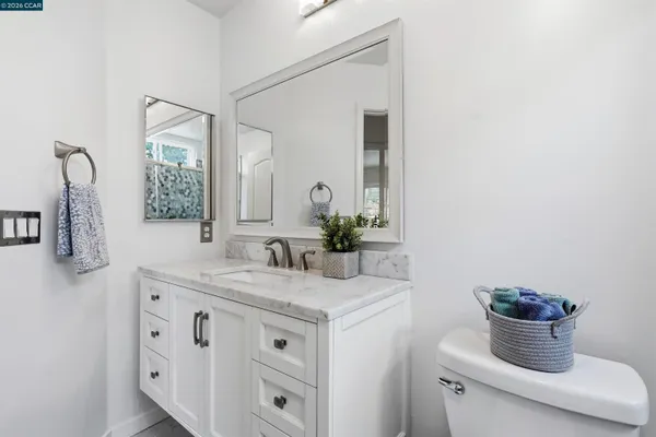 a bathroom with a granite countertop sink and a mirror
