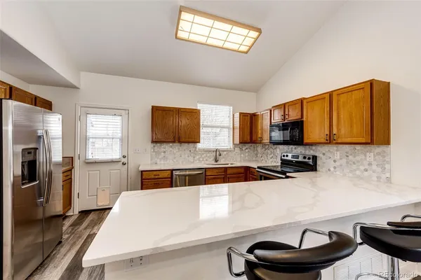a kitchen with a refrigerator and a stove top oven