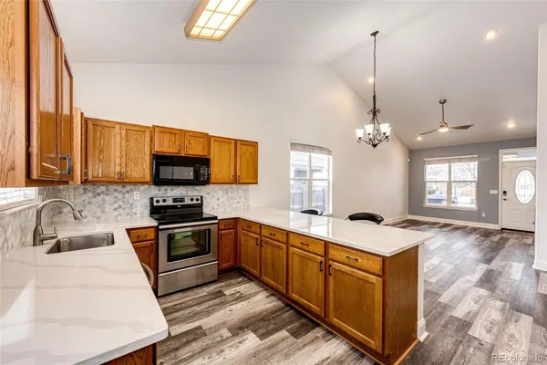 a kitchen with stainless steel appliances granite countertop a sink stove and refrigerator