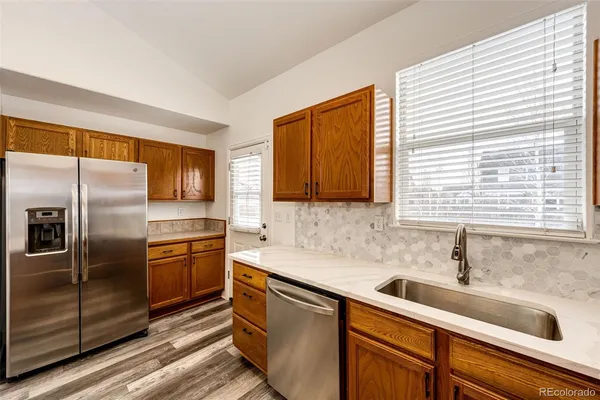 a kitchen with stainless steel appliances granite countertop a sink and a refrigerator